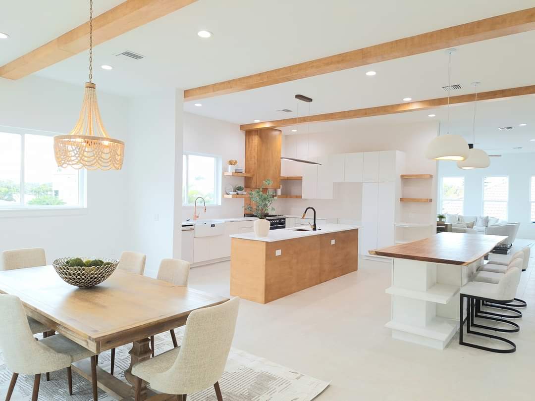 Dining room with wood table and beaded chandelier, sightline through to open kitchen