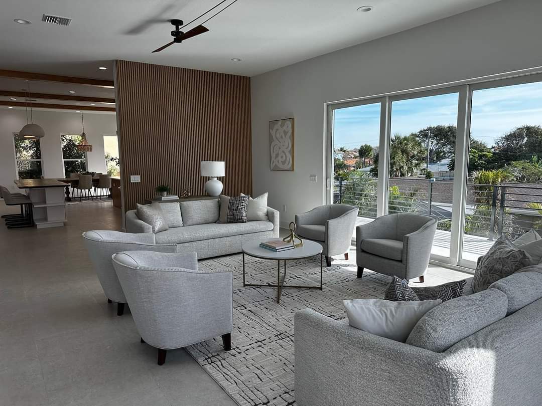 Living room with gray seating arrangement, vertical wood slat accent wall, and glass sliding doors to balcony