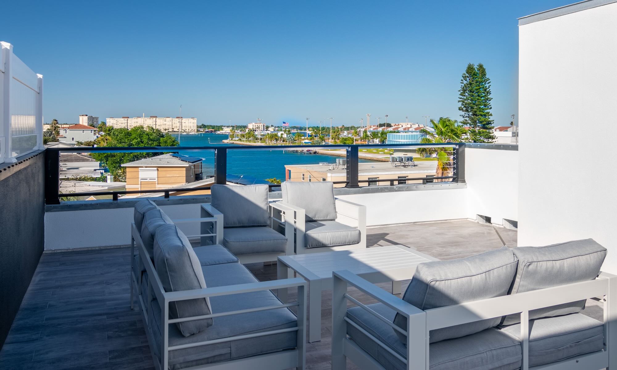 Rooftop deck with outdoor lounge seating overlooking the Intracoastal Waterway and surrounding Madeira Beach skyline