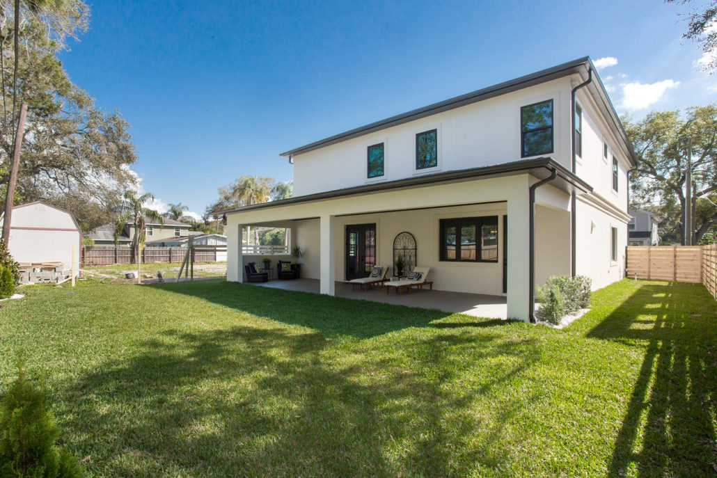 Rear elevation of a two-story South Tampa home showing a covered porch and simple white stucco facade