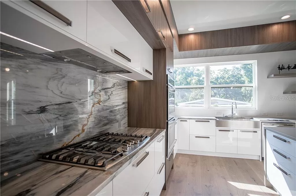 Kitchen wall with a built-in glass-front wine refrigerator, walnut-toned upper cabinetry, and floating open shelving